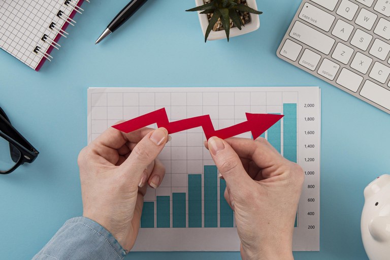 top-view-business-items-with-growth-chart-hands-holding-arrow.jpg